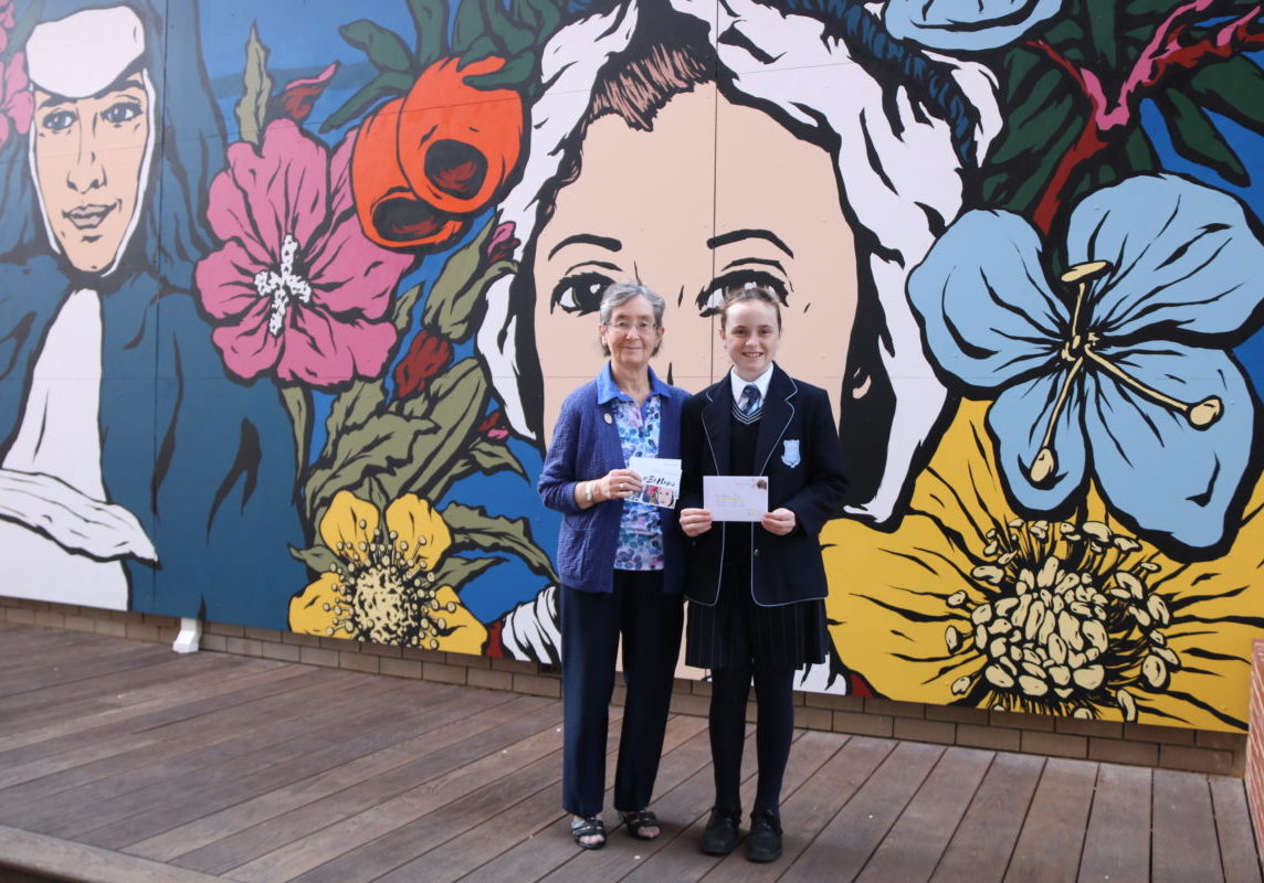 Iona Presentation College student, Matilda, and Sr Gabrielle Morgan, Congregation Leader of the Tasmanian Presentation Sisters, show the postcards they sent each other as part of an Iona Presentation College gratitude project.
